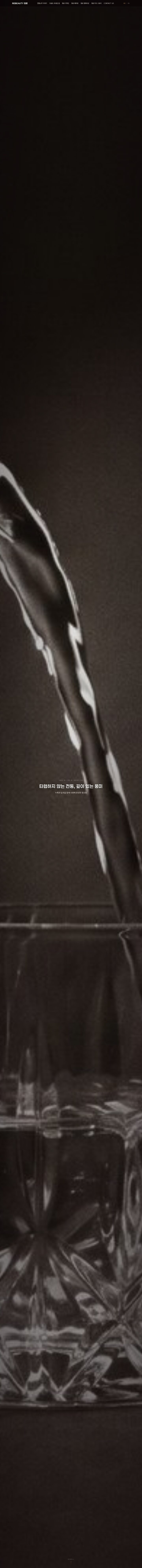 전통 증류주를 잔에 따르는 장면의 흑백 풀스크린 히어로 홈페이지 디자인